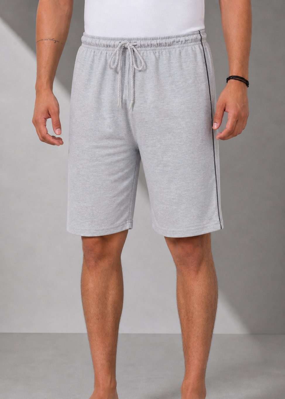 Person wearing gray shorts on a plain background
