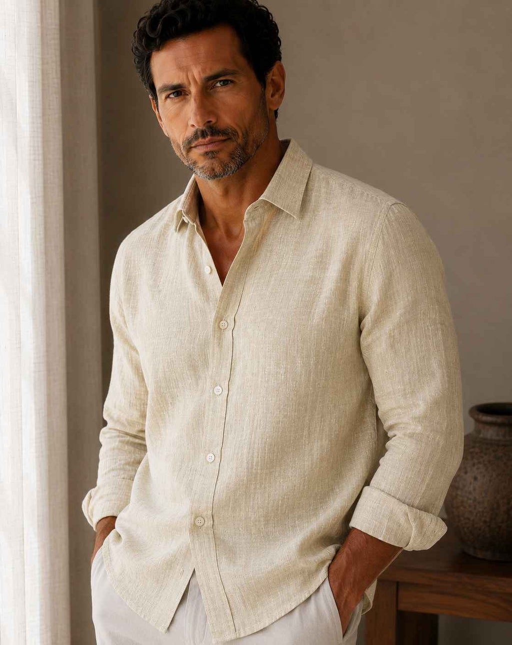 Man wearing a beige linen shirt in a room with a neutral background