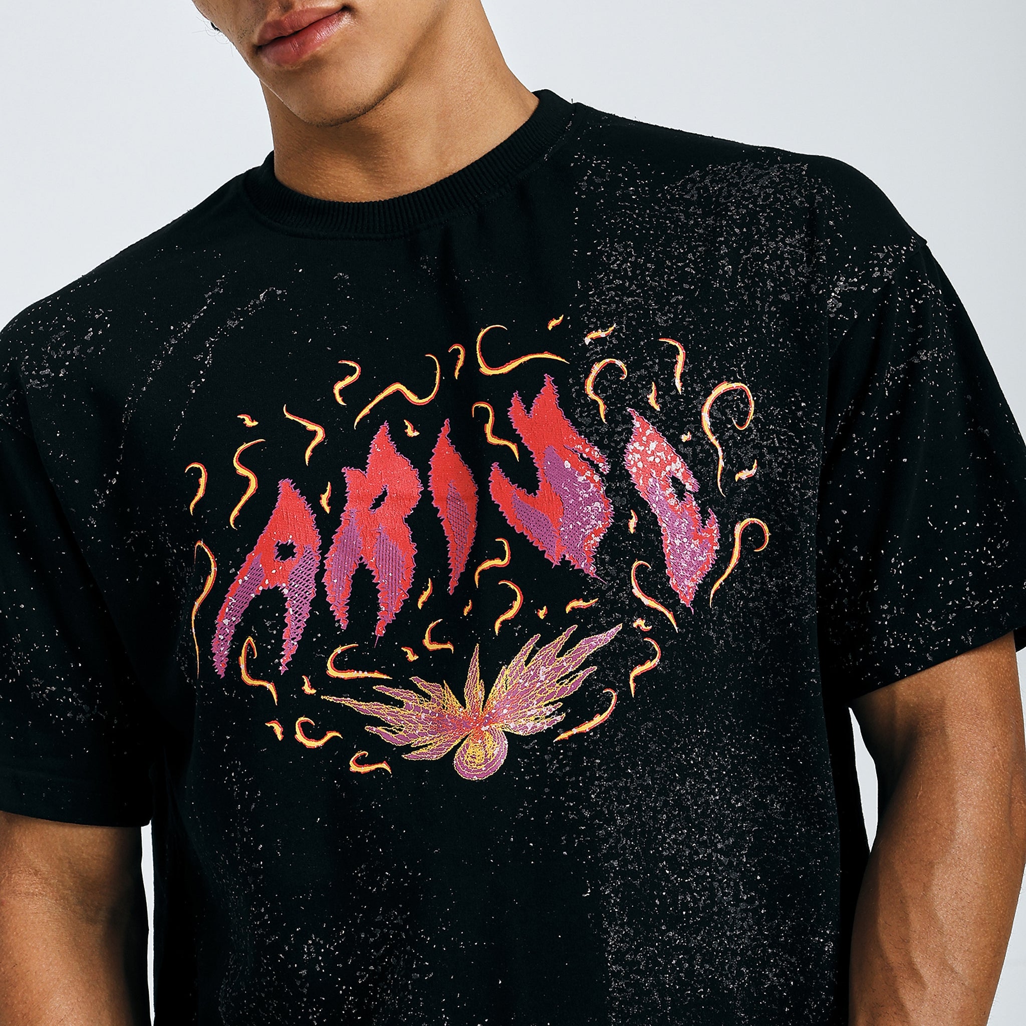 Close-up of black Arise graphic tee with fiery psychedelic design on chest