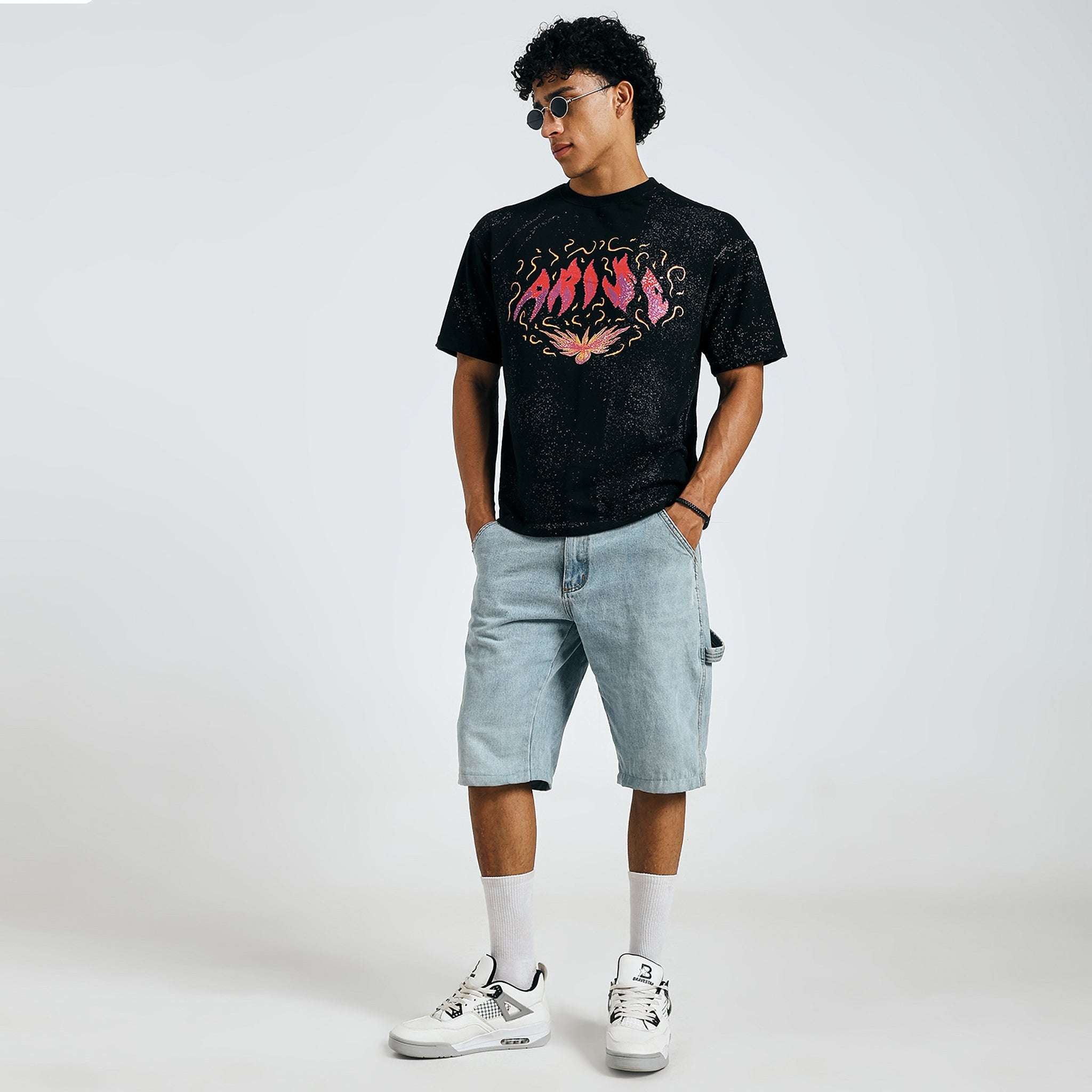 Buy black Arise graphic tee, fashion pose with sunglasses, on model.