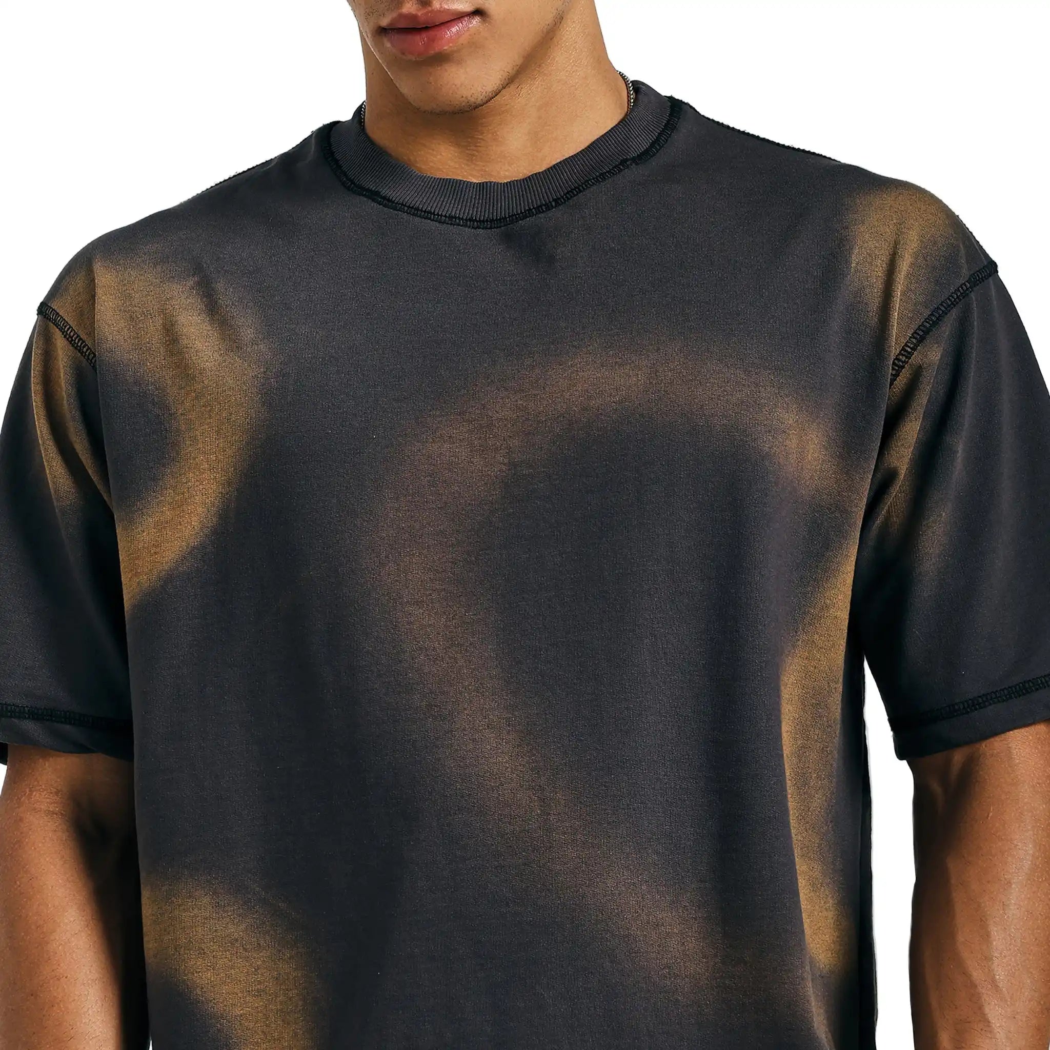 Close-up of black tie-dye mandala tee with subtle brown spray wash effect on chest.