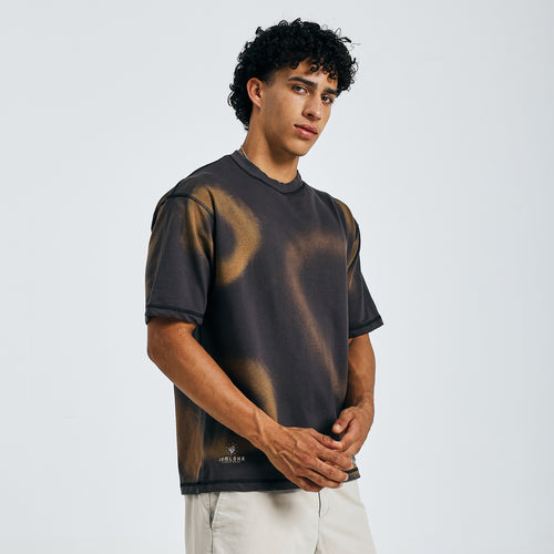 Buy black tie-dye mandala tee, front view, hands clasped, with beige shorts on model.
