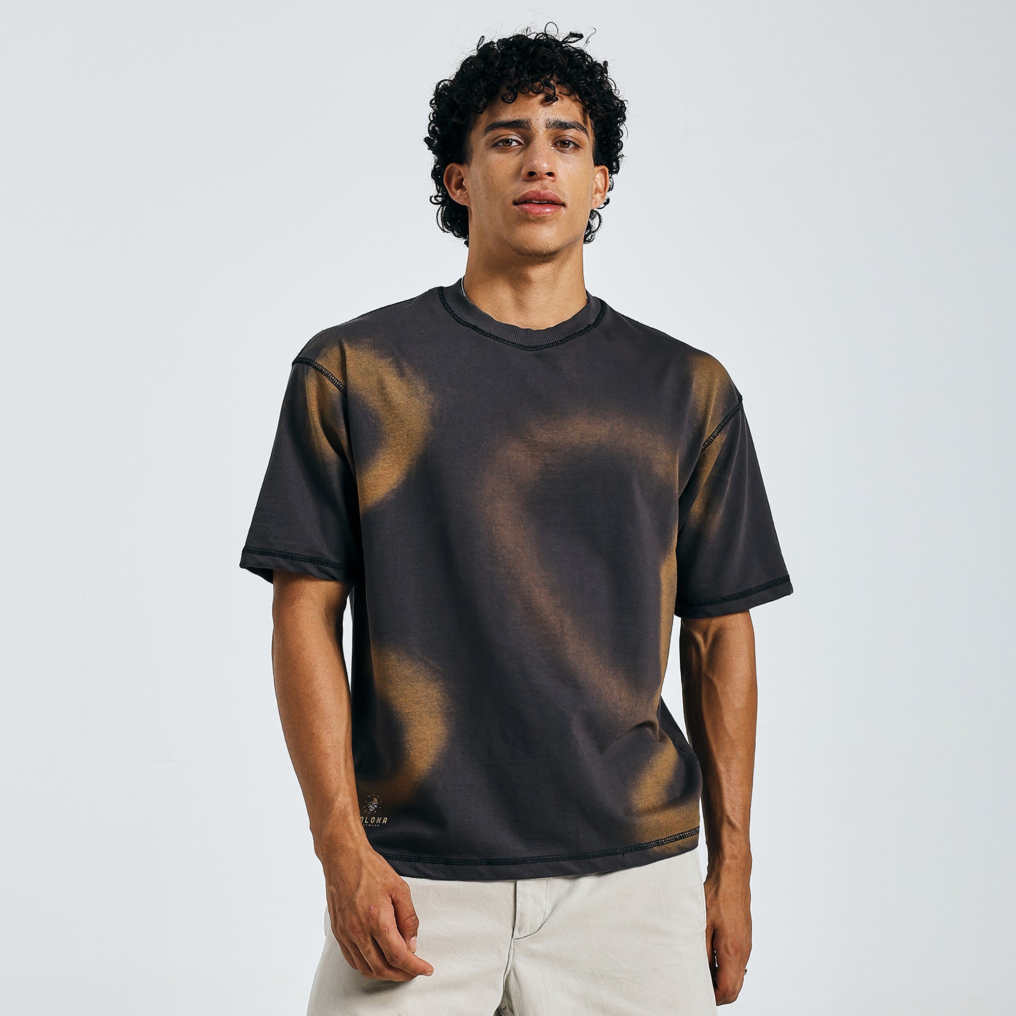 Black tie-dye mandala tee in urban casual style, walking in daylight with beige shorts.