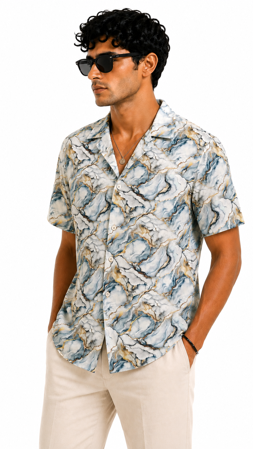 Man wearing a patterned shirt and sunglasses on a white background