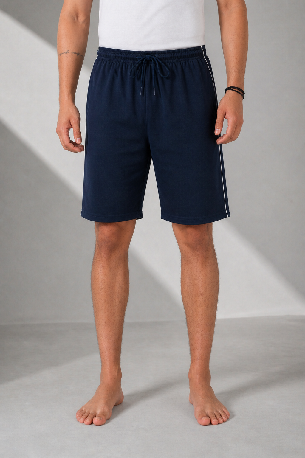 Person wearing navy shorts on a gray background