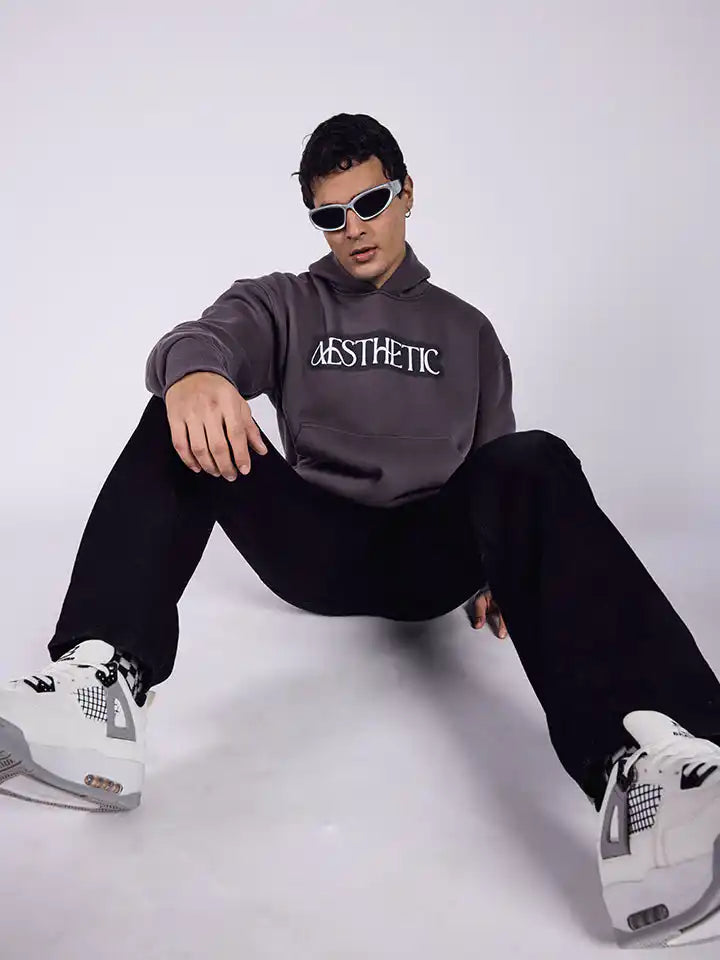 A dark grey oversized hoodie with aesthetic art screen printed on the front and back.