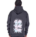 A person wearing a charcoal gray hoodie with a floral pattern on the back, facing away from the camera.