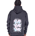 A person wearing a charcoal gray hoodie with a floral pattern on the back, facing away from the camera.