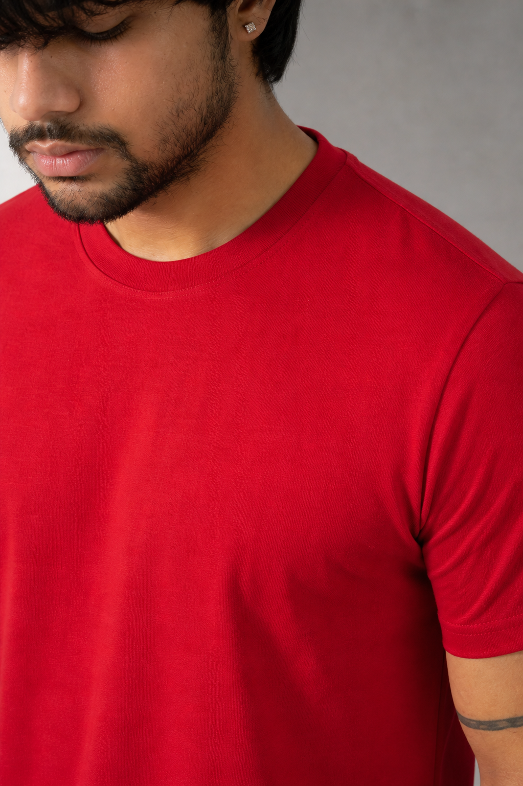Person wearing a red t-shirt against a neutral background