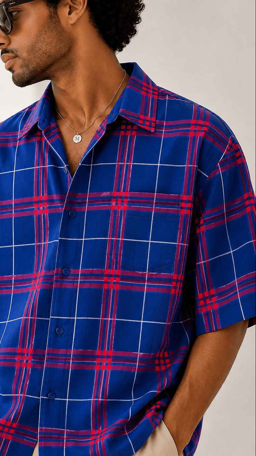 Man wearing a blue and red plaid shirt against a white background