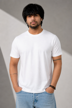Person wearing a plain white t-shirt and light blue jeans against a gray background