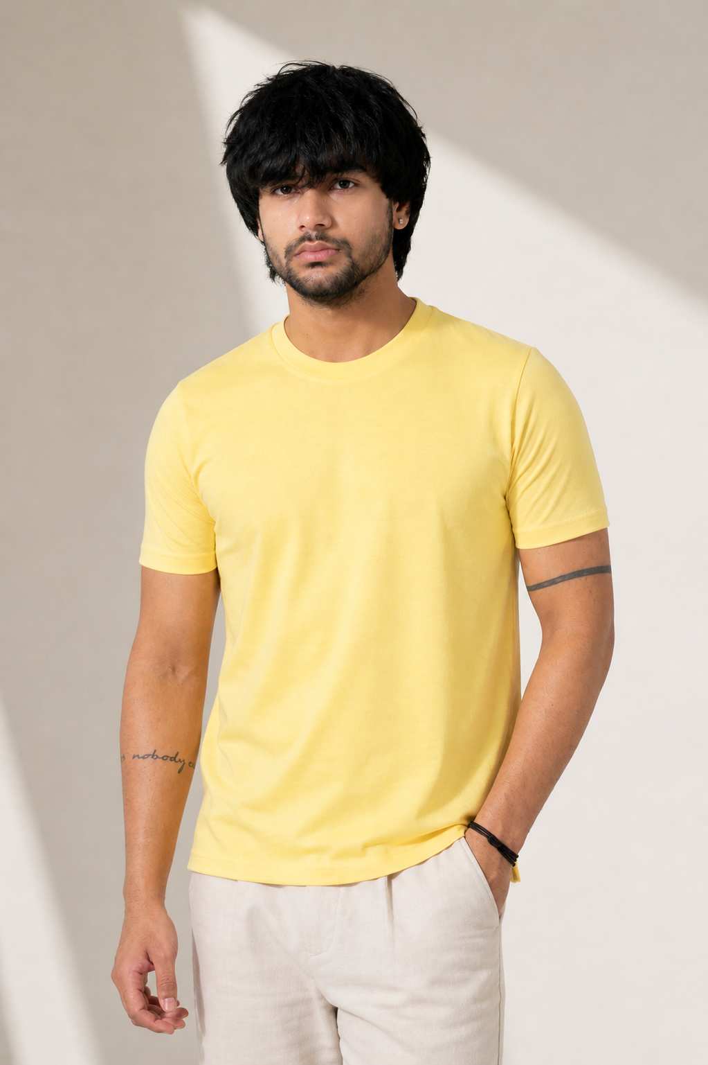 Man wearing a yellow t-shirt against a neutral background